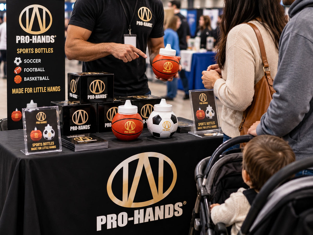 PRO-HANDS SPORTS product fair booth with parents and toddler viewing basketball and soccer sports bottles